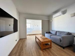 a living room with a couch and a table at Penthouse panoramique avec Jacuzzi in Ajaccio