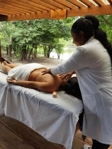 a woman getting a massage from a woman on a bed at Manati Lodge in Manacapuru