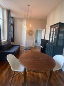a living room with a table and chairs and a couch at Le Philibert Roux Centre Ville d'Auxerre in Auxerre +21 photos