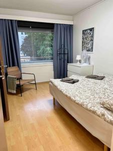 ein Schlafzimmer mit einem Bett, einem Stuhl und einem Fenster in der Unterkunft Viihtyisä kaksio lähellä keskustaa ja yliopistoa. in Turku