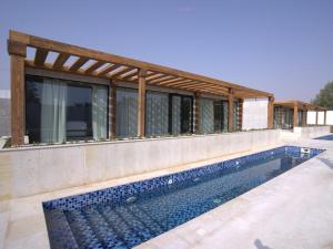 a house with a swimming pool next to a building at AL JUNAIDI FARM BY BRIDGE RETREATS in Sharjah