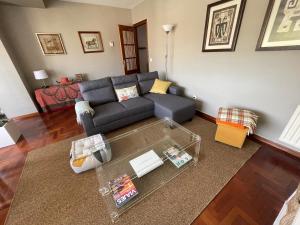 - un salon avec un canapé et une table en verre dans l'établissement Precioso duplex en Nigrán, à Nigrán