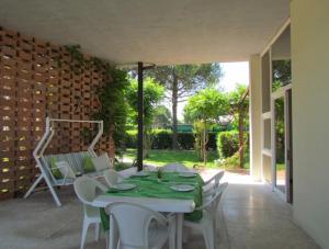 um pátio com uma mesa e cadeiras e uma parede de tijolos em Your relaxing family escape - Beahost em Bibione