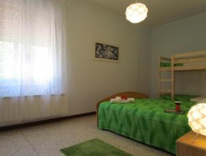 um quarto com uma cama com um cobertor verde em Your relaxing family escape - Beahost em Bibione