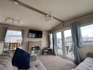 a living room with a couch and a fireplace at The Pastures Holiday Lodge in Tattershall