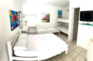 Habitación blanca con cama y TV en Pousada Brasil Natal, en Natal