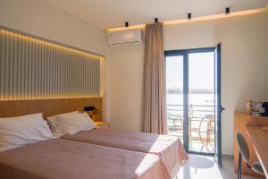 sypialnia z łóżkiem i oknem z balkonem w obiekcie Arocaria Apartments w Chanii