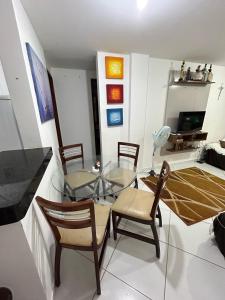 a living room with a glass table and chairs at Apartamento no Condomínio Mar & Sol in Conde