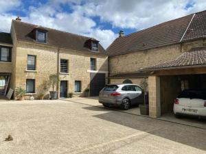 two cars parked in a parking lot in front of a building at Maison de Caractère in Villers-sous-Saint-Leu