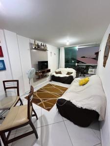 a bedroom with two beds and a table and chairs at Apartamento no Condomínio Mar & Sol in Conde