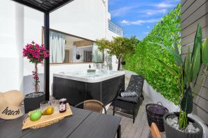 een hot tub op een patio met een tafel en stoelen bij Evi's Afandou Suite in Afantou
