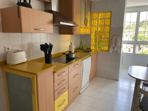 cocina con armarios de madera y encimera amarilla en Precioso duplex en Nigrán, en Nigrán
