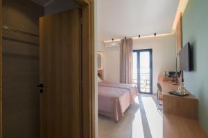 a bedroom with a bed and a television in a room at Arocaria Apartments in Chania