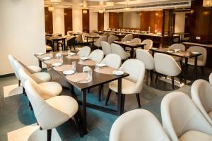 a dining room with tables and white chairs at HOTEL LAKE VIEW in Baharampur