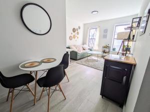 ein Wohnzimmer mit einem Tisch, Stühlen und einem Spiegel in der Unterkunft Oasis Apartment in the Heart of Union Square Downtown Manhattan in New York