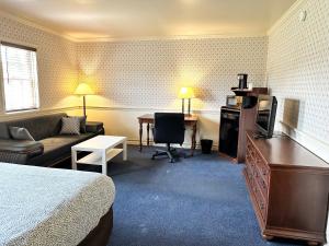 a hotel room with a bed a couch and a desk at Kiteville Lancaster in Strasburg