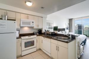 a kitchen with white cabinets and a sink at City View Balcony steps from Restaurants, Peacock Park & Marina in Miami