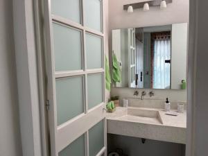 baño con lavabo y espejo grande en Casa La Luz 1, en San Miguel de Allende