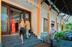 un grupo de personas caminando fuera de una casa en AIDA Hotel - Bentota, en Bentota