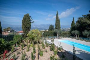 uma imagem de uma piscina num jardim com árvores em GuestReady - Elegant nature escape in vibrant Nice em Nice