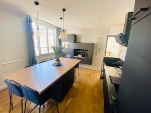 a kitchen with a wooden table and blue chairs at Appartement 6 personnes hyper-centre de Tours in Tours