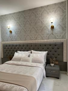 um quarto com uma cama grande e duas luzes na parede em Hotel Golden Star em Taounate