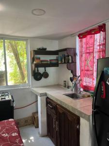 una pequeña cocina con fregadero y ventana en Baba’s Beach Bungalow en Providencia