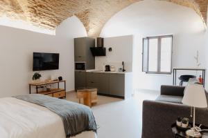 a bedroom with a bed and a couch and a tv at PORTAL DE SANTIAGO in Cáceres