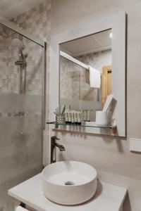 een witte badkamer met een wastafel en een spiegel bij PORTAL DE SANTIAGO in Cáceres
