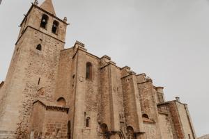 een oude kerk met een klokkentoren bovenop bij PORTAL DE SANTIAGO in Cáceres