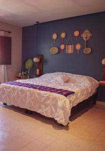 a bed in a bedroom with a wall with many plates at Casa Oaxaca in Oaxaca City