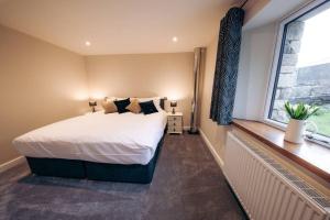 a bedroom with a large bed and a window at Meadow View near Settle. Short walk to food pub in Settle