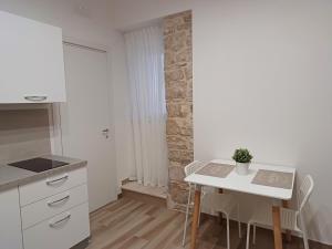 uma cozinha branca com mesa e cadeiras em Vicolo 107 em Sannicandro di Bari