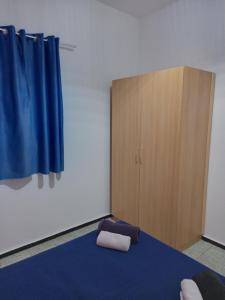 een kamer met een bed en een houten kast bij Pension Alvarez in El Tablero
