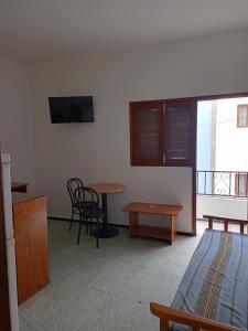 a room with a bed and a table and a tv at Pension Alvarez in El Tablero