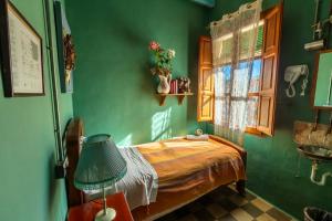 1 dormitorio con 1 cama en una pared verde en Ibiza Boutique Guest House en Ibiza