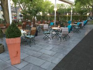 eine Terrasse mit Tischen und Stühlen in einem Restaurant in der Unterkunft Hotel Ragusa in Dormagen