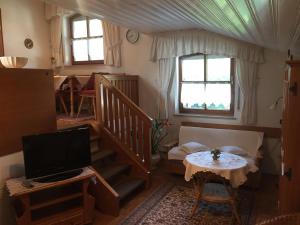 a living room with a staircase and a television at Appartementhaus Moser in Bad Füssing