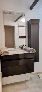 a bathroom with a sink and a large mirror at Le Cocon de Sisteron in Sisteron