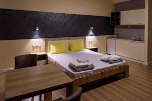 Kriva Palanka的住宿－Noble House，一间卧室配有一张带黄色枕头和桌子的床