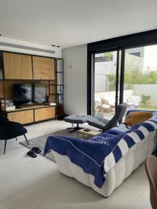 a living room with a bed and a flat screen tv at Aloni House In Dagan in Even Yehuda