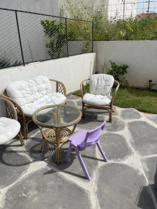 two chairs and a glass table and chairs on a patio at Aloni House In Dagan in Even Yehuda
