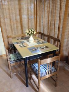 a dining room table with a vase of flowers on it at Aliz és Martin vendégház in Balatonmáriafürdő