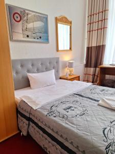 a bedroom with a large bed with a white blanket at City Pension Berlin in Berlin