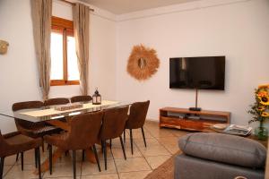 a living room with a dining room table and a tv at Vivienda Rural Casa Tavara in El Ojuelo