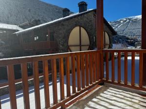 a balcony of a house with a wooden railing at Estudio reformado Vall d'Incles Grandvalira, 4 pers, max 2 adultos y 2 niños menores 12 años in Canillo