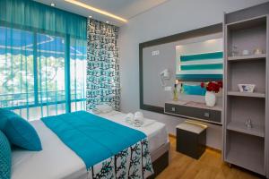 Un dormitorio con una cama azul y una ventana en Astris Beach, en Astris