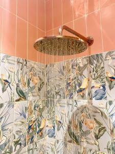 a shower in a bathroom with birds on the wall at Emerald villa Yenibogazici in Yenibosazici