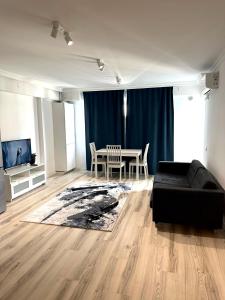 VoluntariにあるSpacious & Cozy Apartment in Pipera with Underground Parking & Self Check in-close to Baneasa Forest & Mall, and the airportsのリビングルーム(黒いソファ、テーブル付)