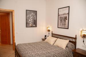 a bedroom with a bed and two pictures on the wall at Vivienda Rural Casa Tavara in El Ojuelo
